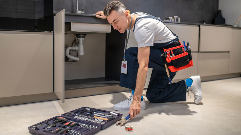 Outils professionnels de plomberie et badge de certification CFC sur établi