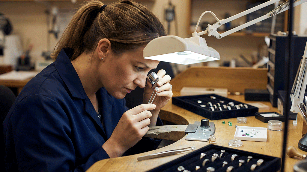 Artisan bijoutier examinant une pièce de gorgone à la loupe