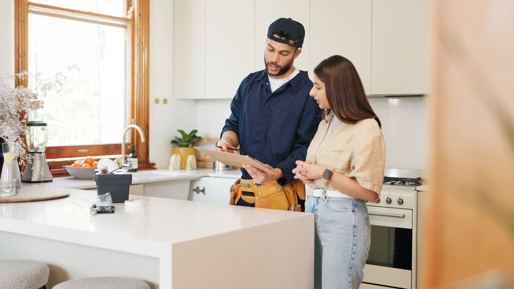 Propriétaire vérifiant la carte professionnelle d'un plombier à l'entrée de son domicile